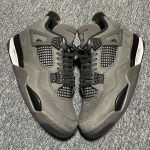 A person wearing the "Cave Stone" Jordan 4